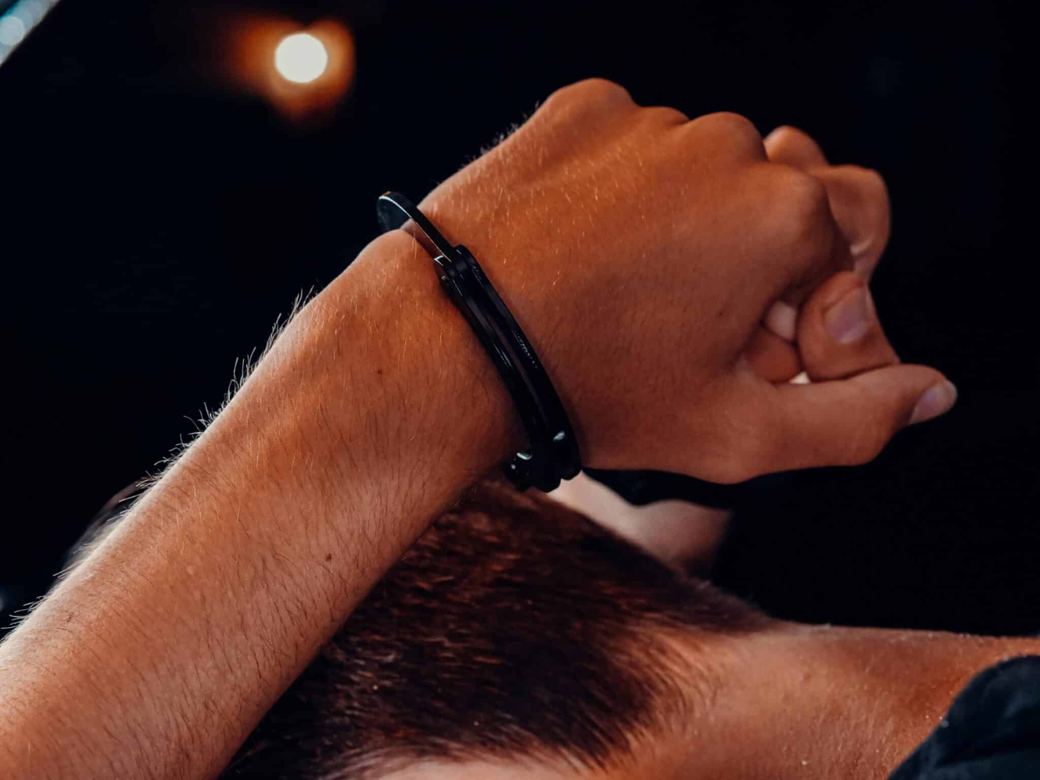 a pair of hands in handcuffs